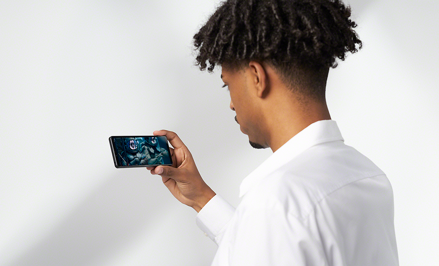Mężczyzna oglądający obraz na wyświetlaczu smartfonu Xperia 10 IV