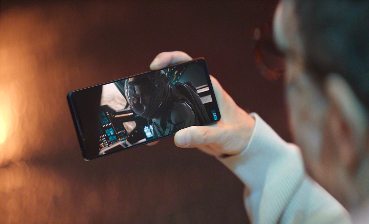 Detailní záběr na ruku osoby, která drží smartphone Xperia 1 IV a prohlíží obsah