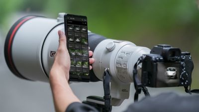 카메라로 촬영하면서 스마트폰을 조작하는 남성 이미지