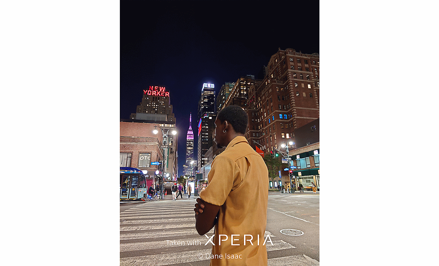 City streets at night with a man in the foreground. Text reads "Taken with XPERIA ©Dane Isaac".