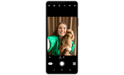 Xperia 10 IV в портретном положении, демонстрирующий селфи женщины, держащей собаку.