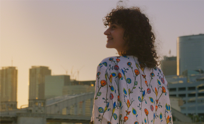 一位女士凝望著城市景觀的低光室外拍攝影像