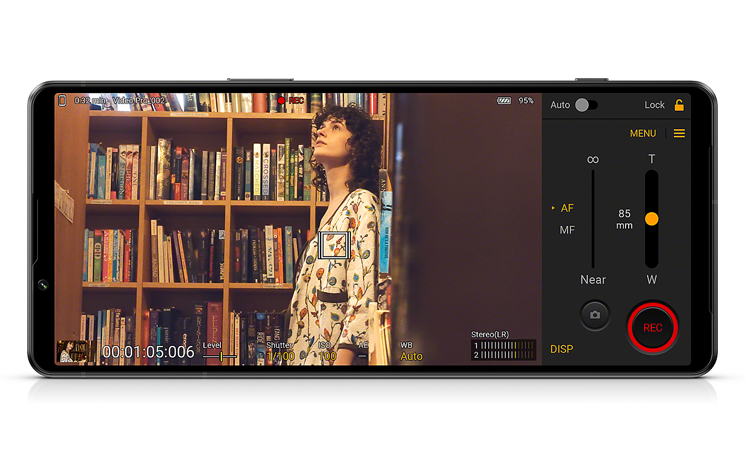 Telefon Xperia 1 IV, ki prikazuje vmesnik Videography Pro in sliko ženske v knjižnici