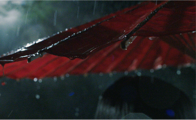 雨落在一把紅色陽傘上