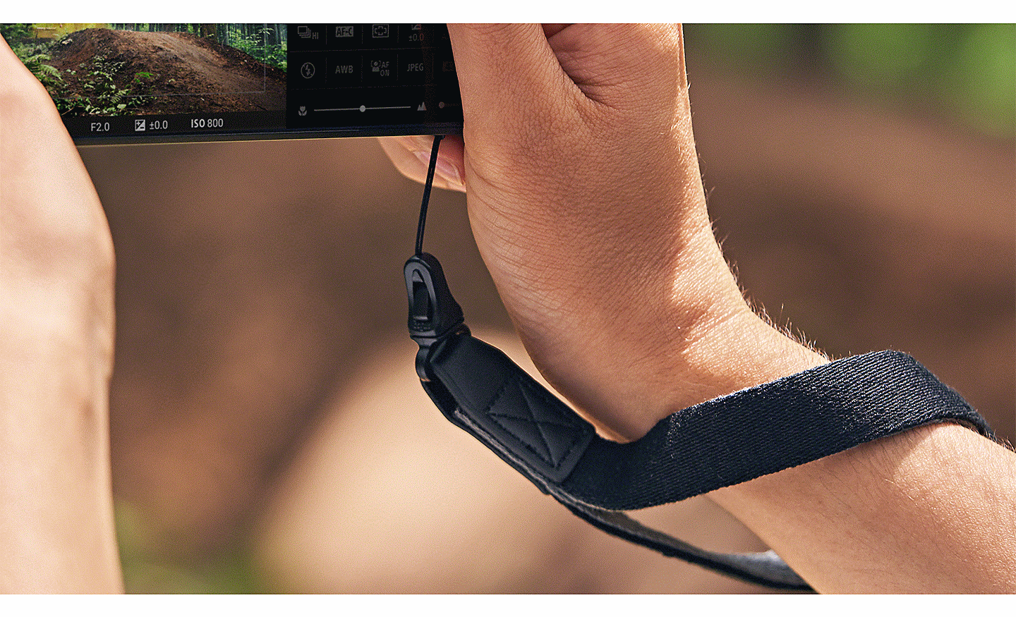 Bàn tay cầm Xperia PRO-I với dây đeo máy ảnh quấn quanh cổ tay.
