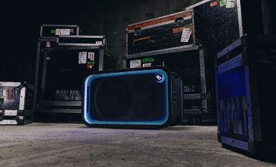 En la imagen proporcionada, hay un parlante de SONY, identificado como el ULT TOWER MAX, destacado en primer plano. En el fondo, hay un grupo de personas bailando en lo que parece ser una fiesta nocturna o una reunión al aire libre. También hay una pequeña etiqueta "FPO" (solo para fines de maquetación) en la esquina superior derecha.