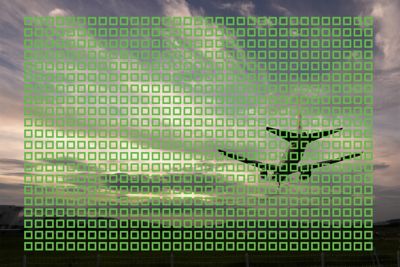 Imagen de ejemplo de un avión en vuelo con pequeños cuadrados que muestran los 693 puntos de AF en toda la imagen