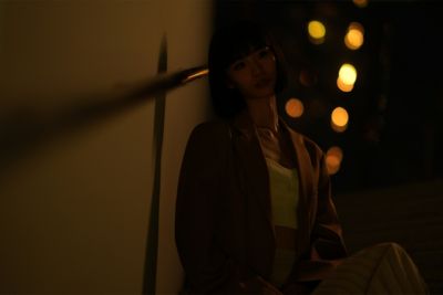 Imagen de una mujer sentada en un espacio con poca luz