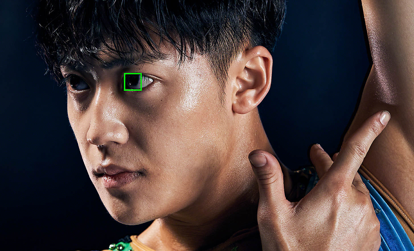 Retrato de un gimnasta hecho con un objetivo de 125 mm. Un cuadro verde sobre uno de sus ojos representa el Eye AF en tiempo real