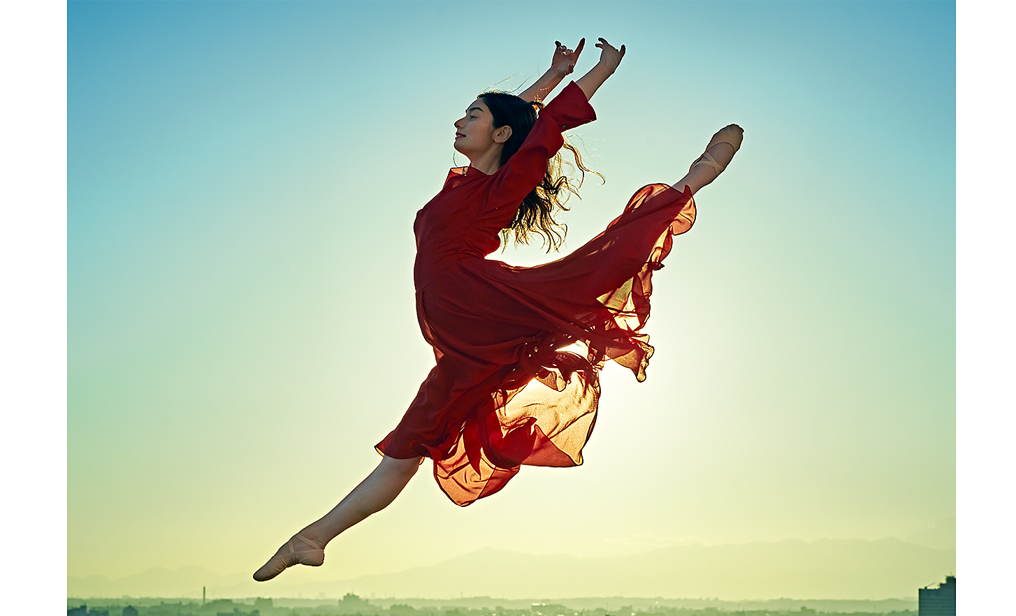 A leaping dancer in a red dress 