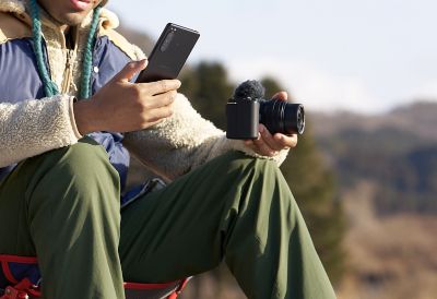Image of a man transferring images from a camera to a smartphone