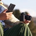 Image of a man transferring images from a camera to a smartphone