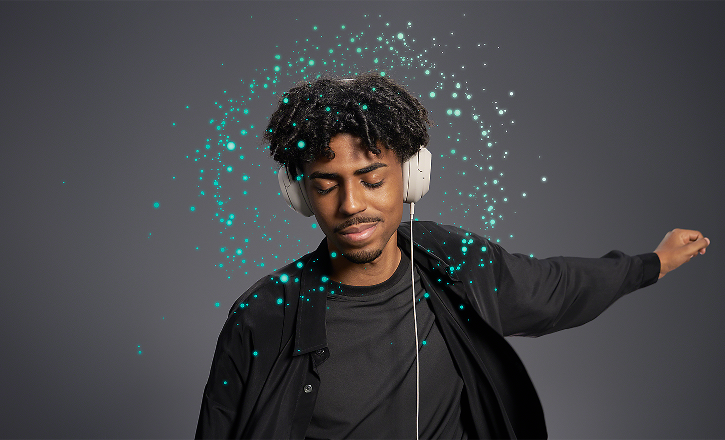 Een man die luistert met een bedrade koptelefoon − lichtpuntjes rond zijn hoofd vertegenwoordigen 360 Reality Audio