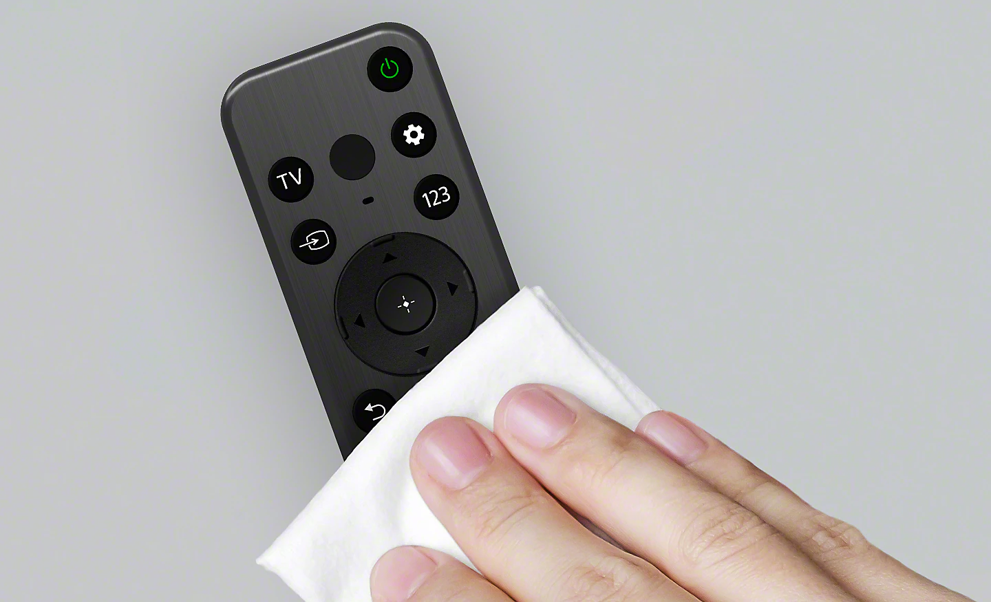 Imagen de un mando a distancia que están limpiando con una toallita