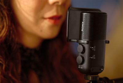 Image montrant une femme chantant avec la bouche près du microphone équipé d'un filtre anti-pop