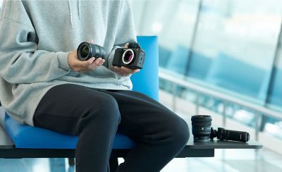 Imagen de un hombre intercambiando el lente de la cámara