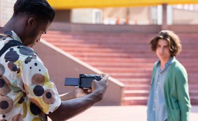 Imagen de un hombre sosteniendo la cámara para filmar a otro hombre al aire libre