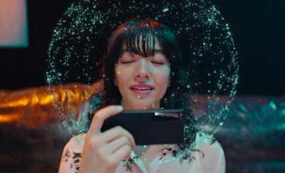 一位閉目的女士正在透過 Xperia 1 IV 的全境立體聲揚聲器聽音樂；她頭上的光點代表 360 Reality Audio