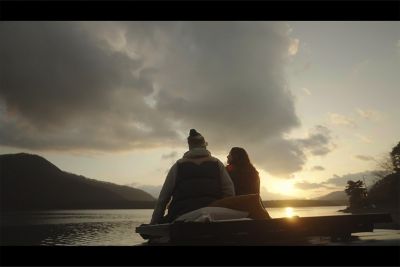 Imagen de dos personas sentadas cerca la una de la otra con una escena de noche en el fondo