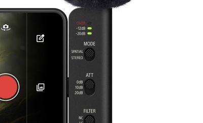 Close-up of an ECM-AX10 microphone on a smartphone, showing LED lights, control switches, and orange plus icons.