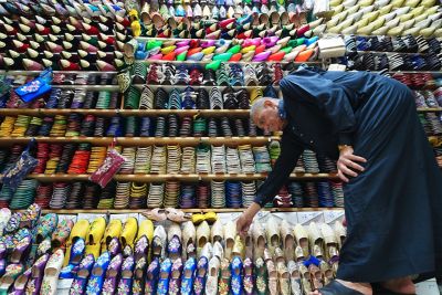 Image of an elderly man selecting a colourful slipper in NT (Neutral) mode.