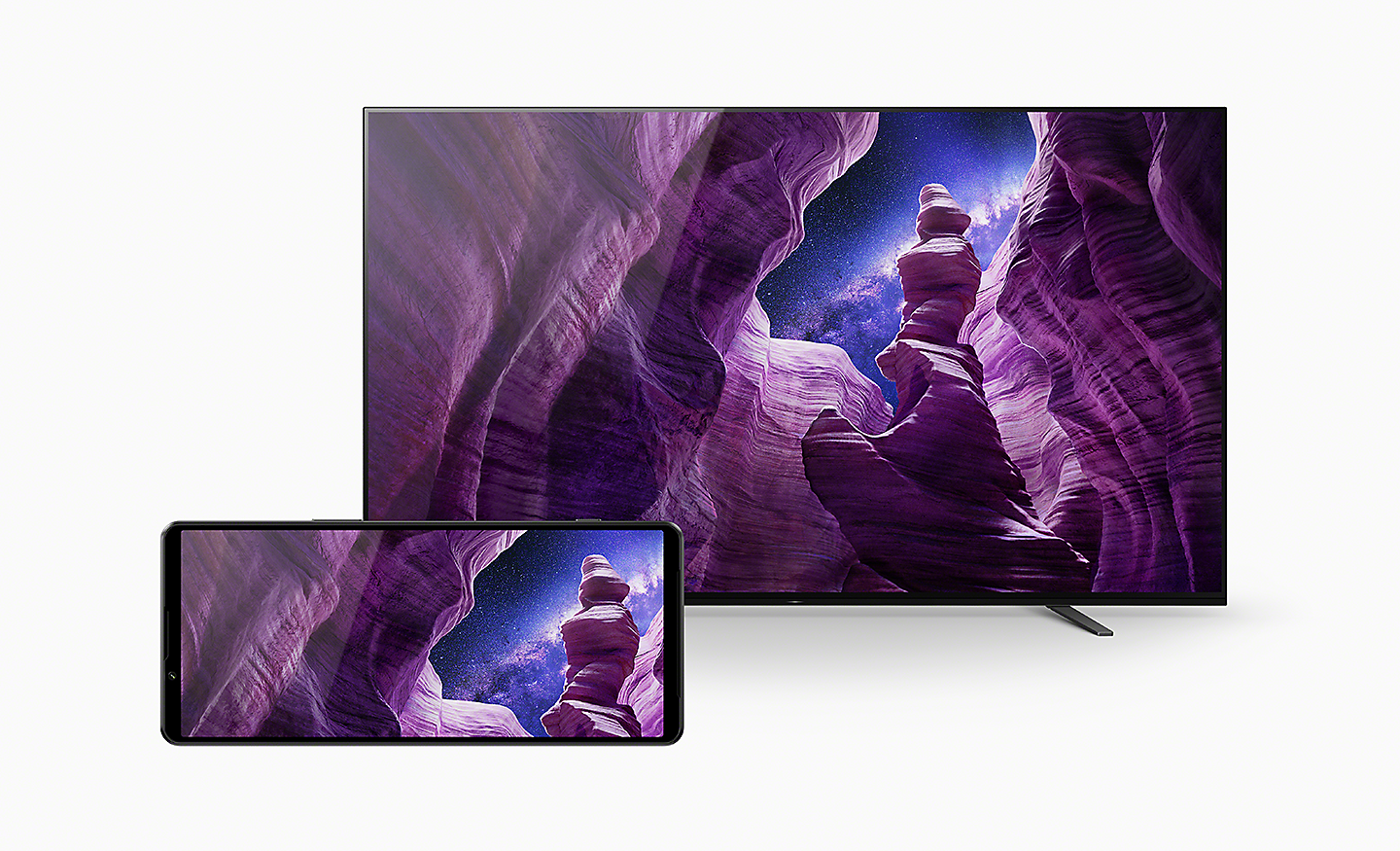 Xperia 1 IV in front of a Sony BRAVIA TV, both displaying an image of a dramatic rock formation