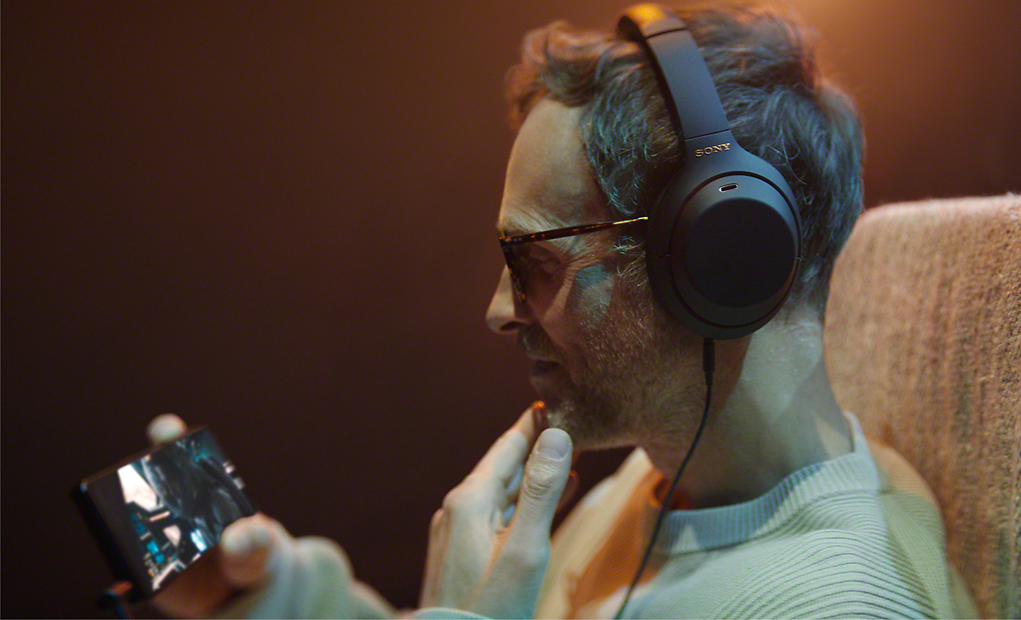 Un hombre con auriculares viendo contenido en su Xperia 1 IV