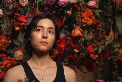 Imagen de una mujer con flores en el fondo