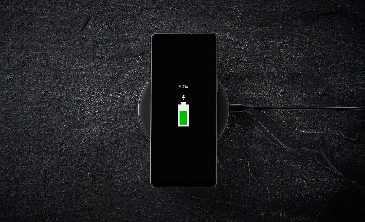 Xperia 1 IV sur une station de recharge sans fil, l’écran affichant l’icône de chargement de la batterie