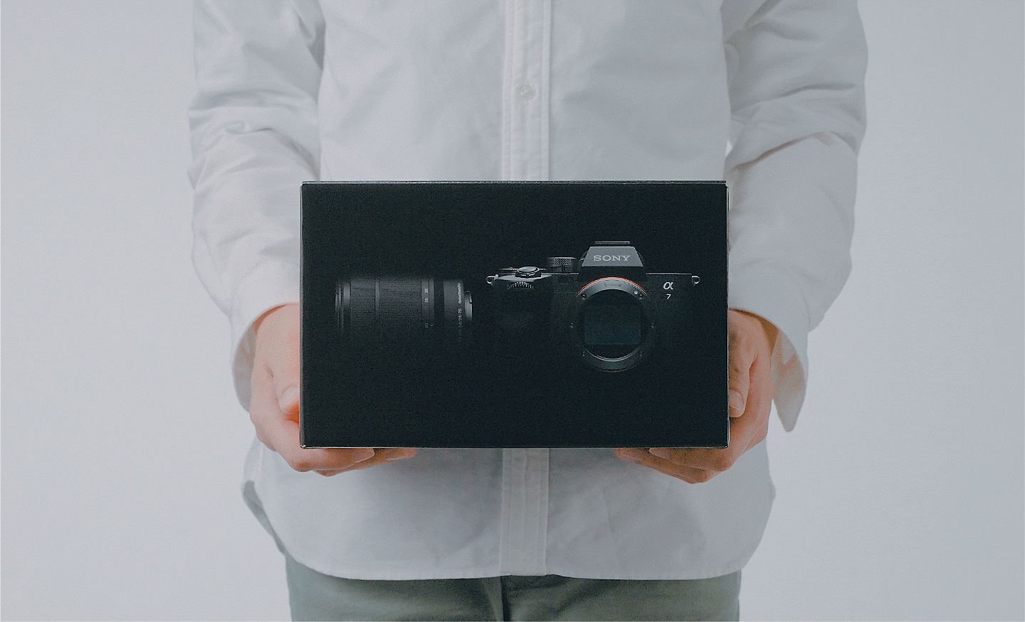 Photo of a person holding a box with the α7 IV inside