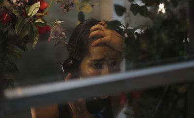  Image through a window with a woman on the phone.