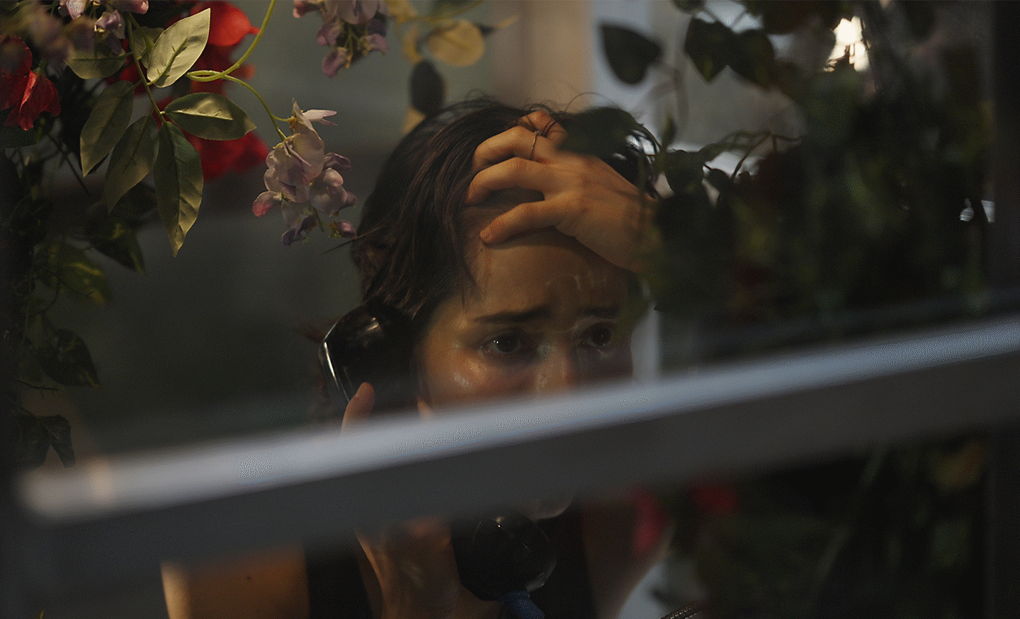  Image through a window with a woman on the phone.