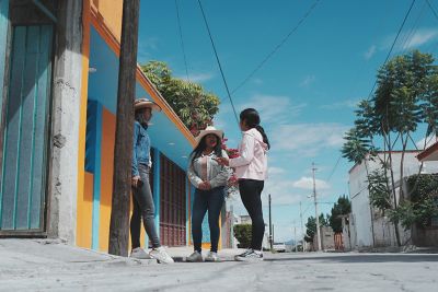 Image of three woman standing and talking on the roadside in IN (Instant) mode.