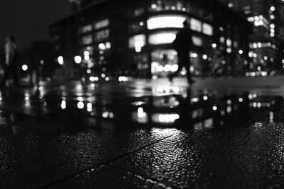 Image of a reflecting puddle with illuminated building in the background in BW (Black & White) mode.