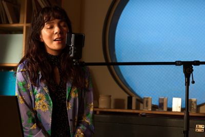 Image montrant une femme chantant dans un microphone installé sur le bras d'une perche