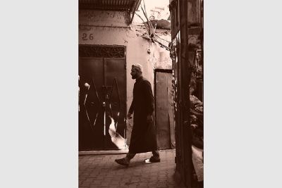 Image of a man walking along the street in SE (Sepia) mode.