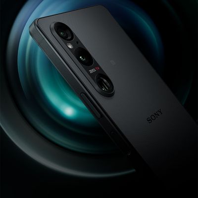 Vista trasera inclinada del Xperia 1 V que muestra la cámara de triple objetivo con un objetivo en primer plano de fondo