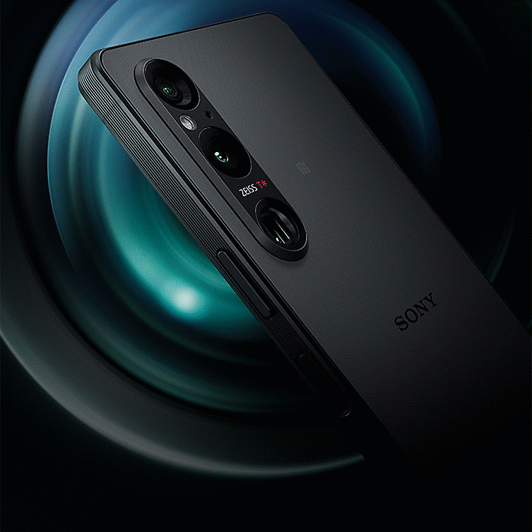 Angled rear view of Xperia 1 V showing its triple lens camera, against a background of a camera lens in close-up