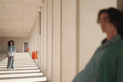 Imagen de ejemplo de una mujer en segundo plano enfocada y un hombre cerca de la cámara en primer plano desenfocado