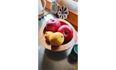 Image of a fruit bowl with two lemons and two red apples