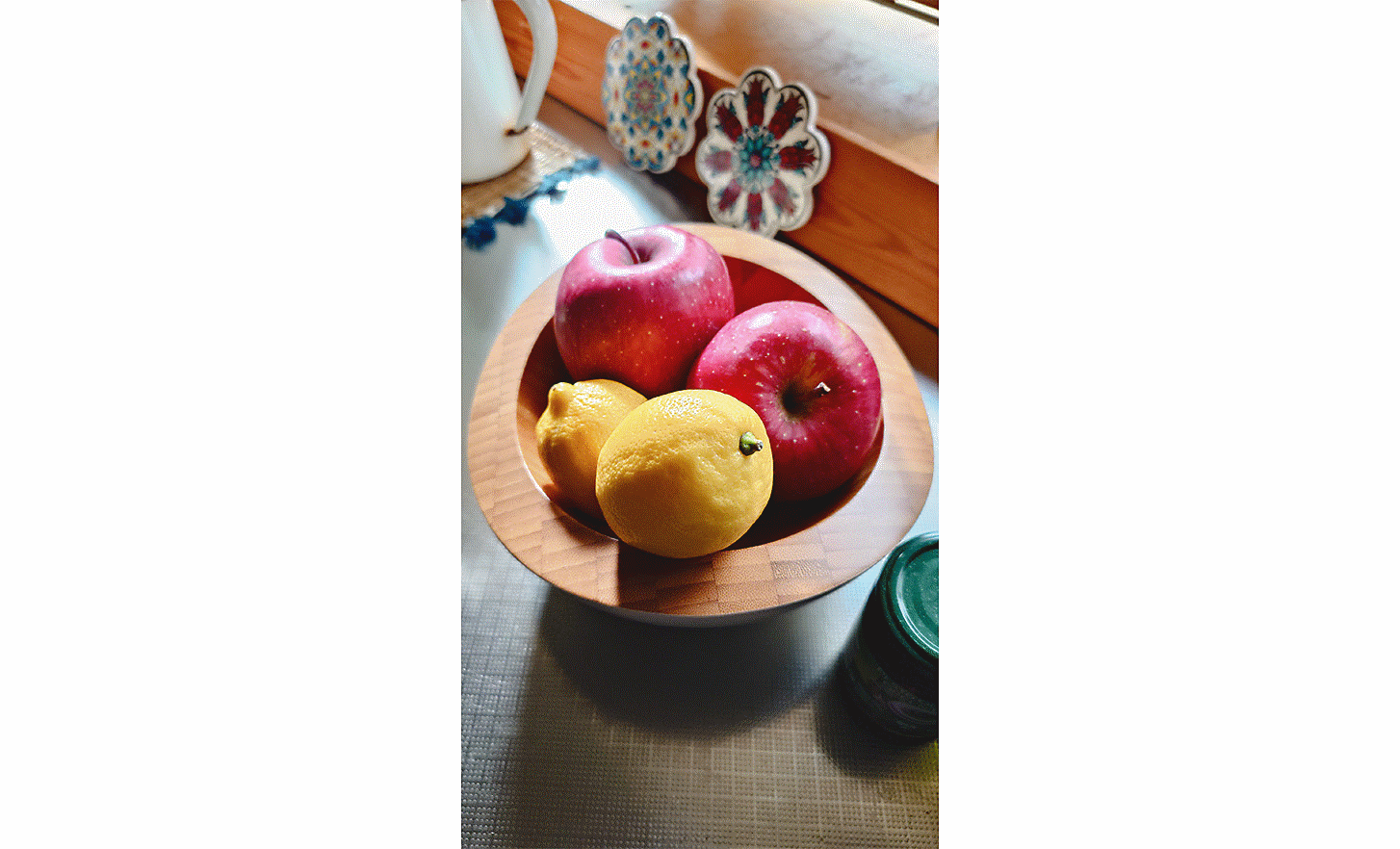 Image d'une coupe de fruits avec deux citrons et deux pommes rouges