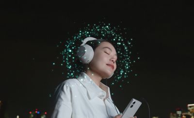 Изображение человека в наушниках, подключенных к Xperia 5 V, с множеством ярких точек вокруг его головы.