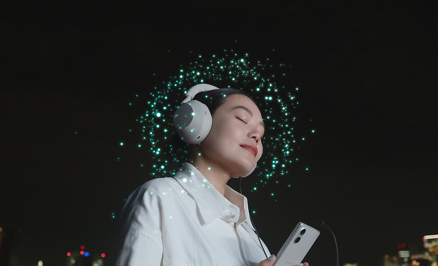 Image of a person wearing headphones connected to an Xperia 5 V with lots of bright dots surrounding their head