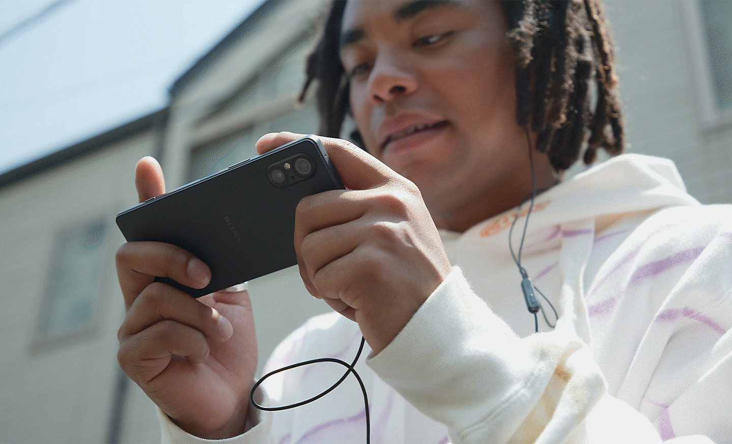 Image d'une personne jouant à un jeu sur un Xperia 5 V noir en extérieur