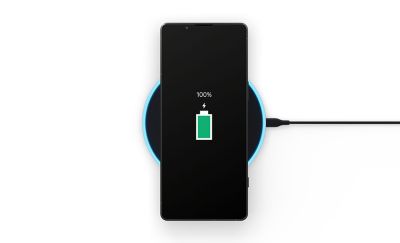 正在基座上充電的 Xperia 5 V 圖片，螢幕顯示電池圖示和「100%」字樣