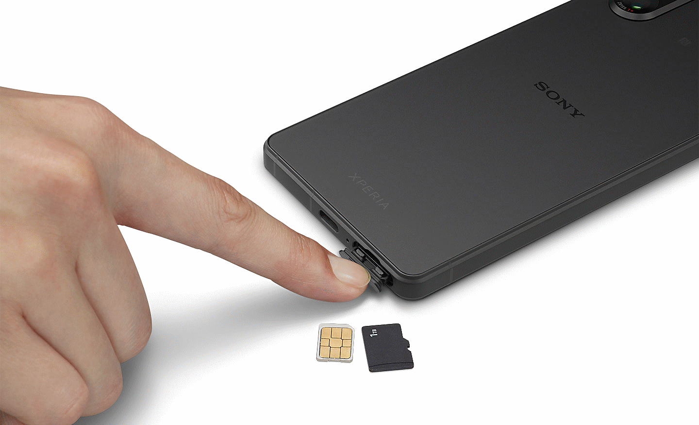 Image d'une personne ouvrant l'emplacement de la carte SIM sur un Xperia 5 V, avec deux cartes SIM posées à côté