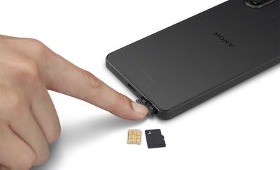 圖片展示有人正在打開 Xperia 5 V 的 SIM 卡槽，旁邊放著兩張 SIM 卡