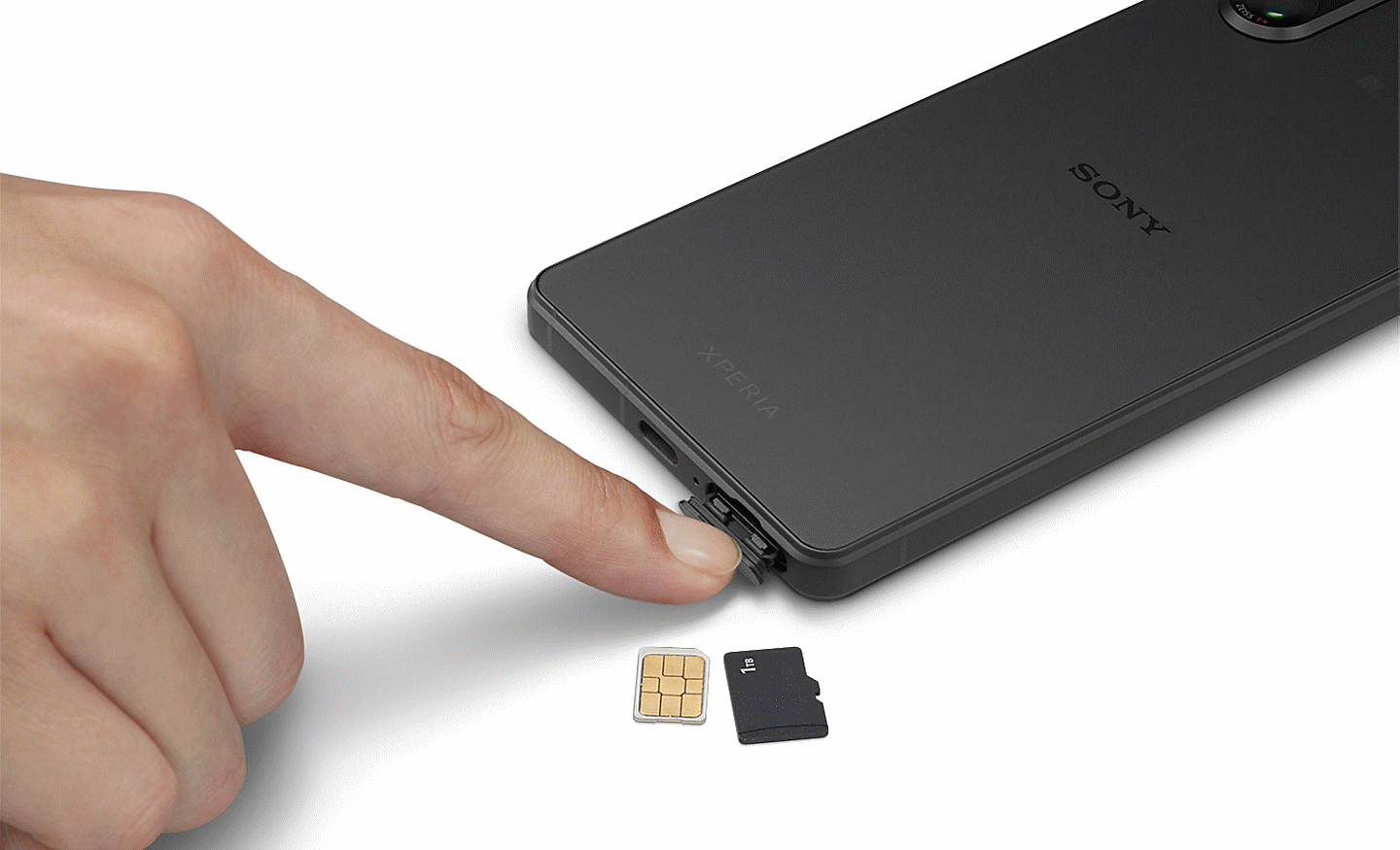 Image of a person opening the sim card slot on an Xperia 5 V, with two sim cards next to it