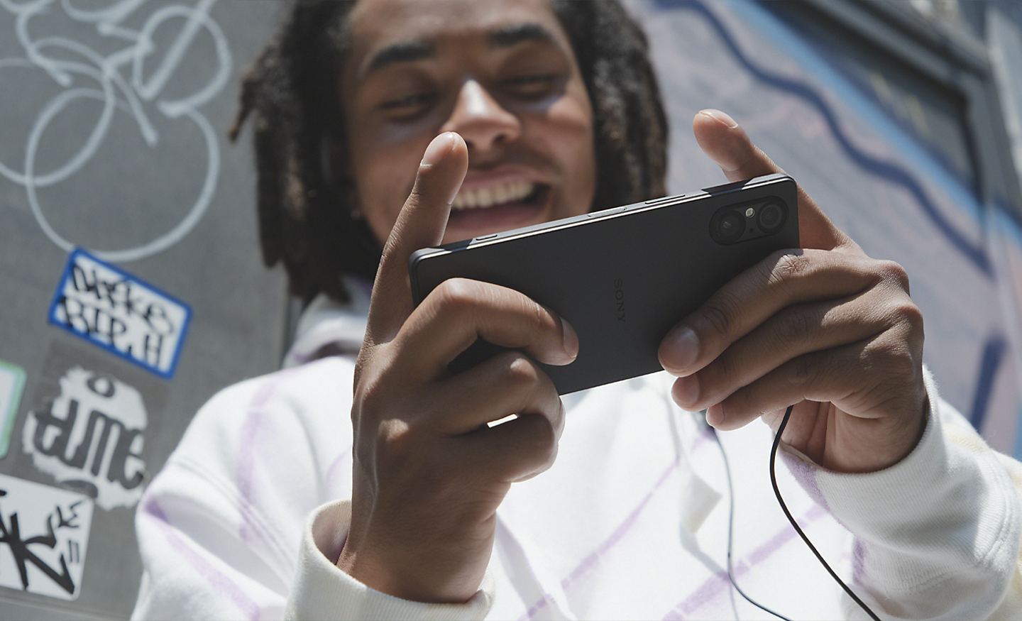 Imagine cu o persoană jucându-se pe un Xperia 5 V negru