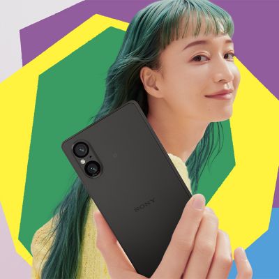 Image 93: Image of a person holding an Xperia phone on a pink background with colourful shapes.